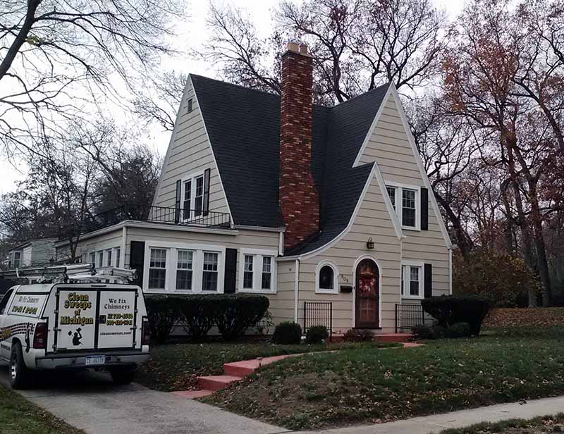 work truck parked outside a house with a brick chimney 